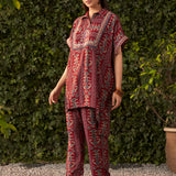 Oblique angle showing fuchsia rayon co ord set with ikat print kaftan top dori embroidery high low hemline and straight pants