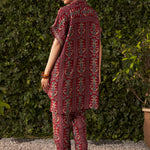 Back view of woman wearing fuchsia pink rayon co-ord set with ikat print, relaxed-fit kaftan top with high-low hemline and straight pants