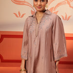 A woman smiling displaying her Niya Oak Brown Embroidered Cotton Linen Slub Long Top for Women