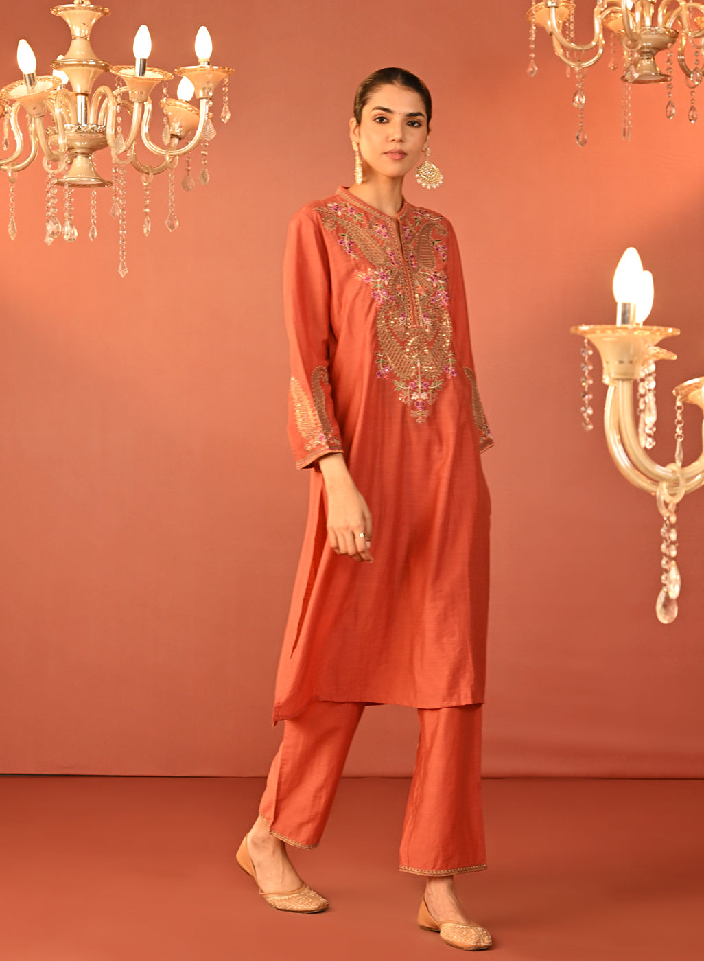 The model is posing with Lakshita's Mohiba Orange Embroidered Co-ord Set 